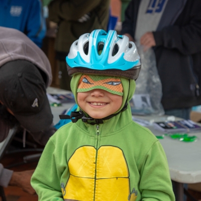 A child being helped to adjust a friendship bracelet